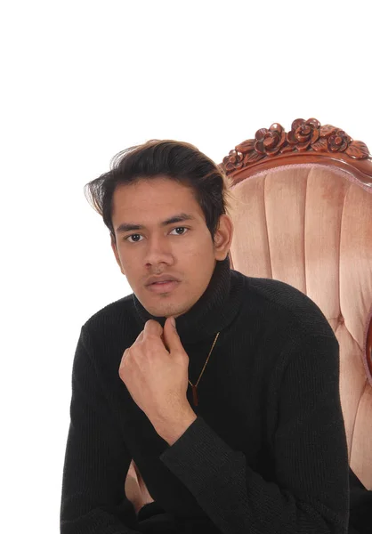 Porträt eines jungen, gut aussehenden Mannes in einem alten Sessel — Stockfoto