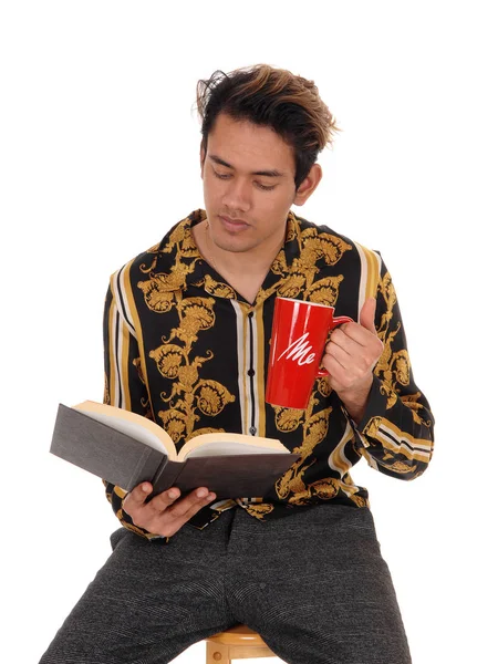 Man zittend op een stoel met zijn koffiemok, lezen — Stockfoto