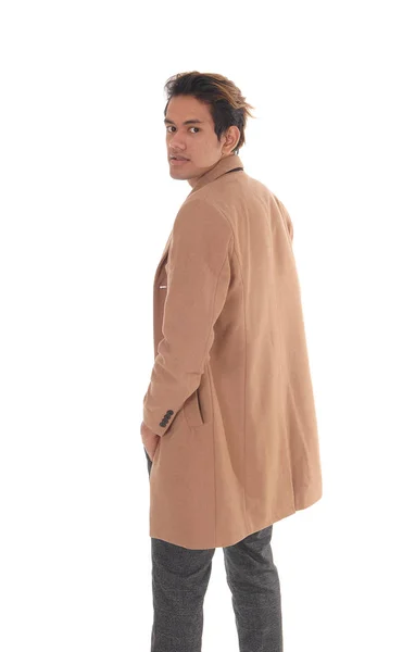 Tall young man standing in a beige coat from the back — Stock Photo, Image