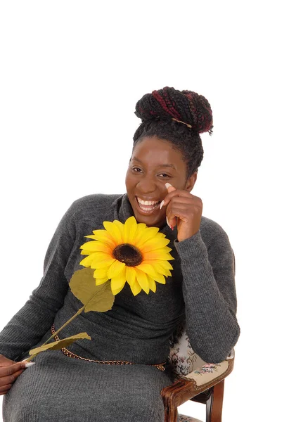 Jeune femme souriante assise avec un tournesol — Photo