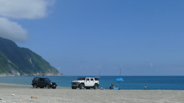 Manden påbyder fiskeri på stranden med dejligt vejr i New Taipei City, Taiwan – Stock-video