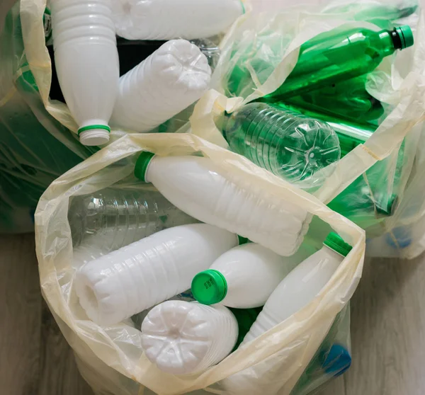 Used white and green plastic in the white bags — Stockfoto