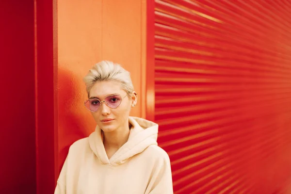 Jeune femme blonde avec des lunettes de soleil roses — Photo