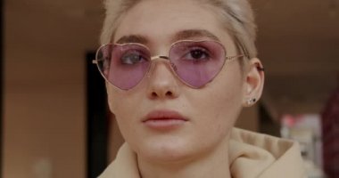 Blond young woman with pink sunglasses