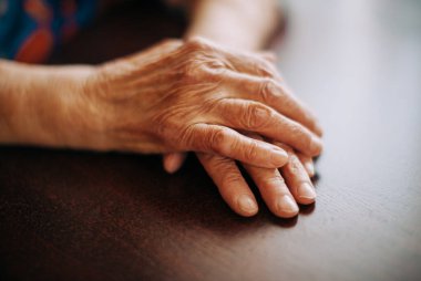 Evdeki gerçek yaşlı kadının elleri, doğal ışık, seçici odak noktası