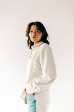 Beyaz arka planda esmer genç bir kadının portresi.