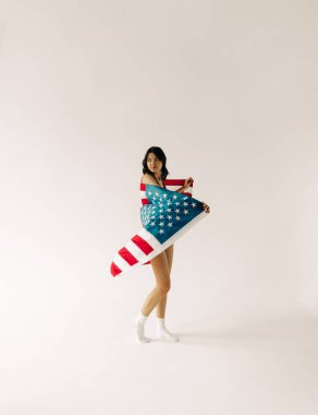 Beyaz arka planda bayrak taşıyan genç bir kadın var.