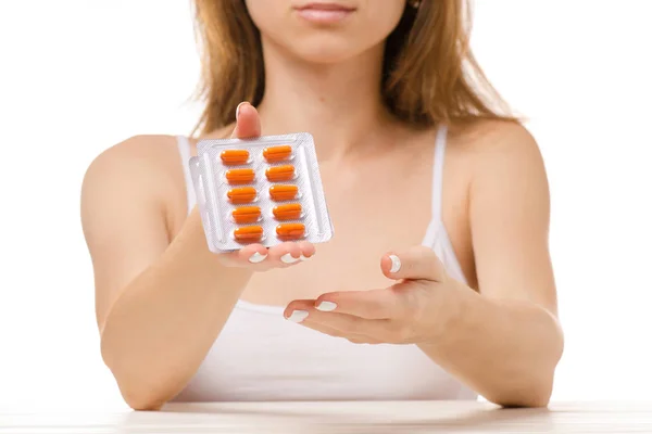 Beautiful woman sitting with pills in hands — Stock Photo, Image