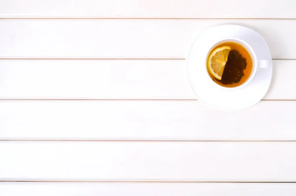Bir fincan çay bir fincan tabağı üzerinde limonlu — Stok fotoğraf