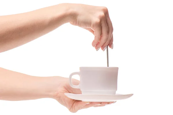 Κύπελλο και πιατάκι με ένα κουταλάκι του γλυκού στον καφέ τσάι χέρια — Φωτογραφία Αρχείου
