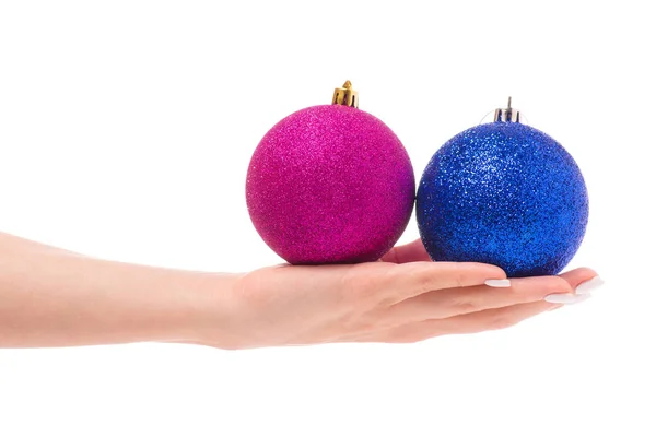 Χριστούγεννα παιχνίδια ροζ μπλε στο γυναικείο χέρι — Φωτογραφία Αρχείου