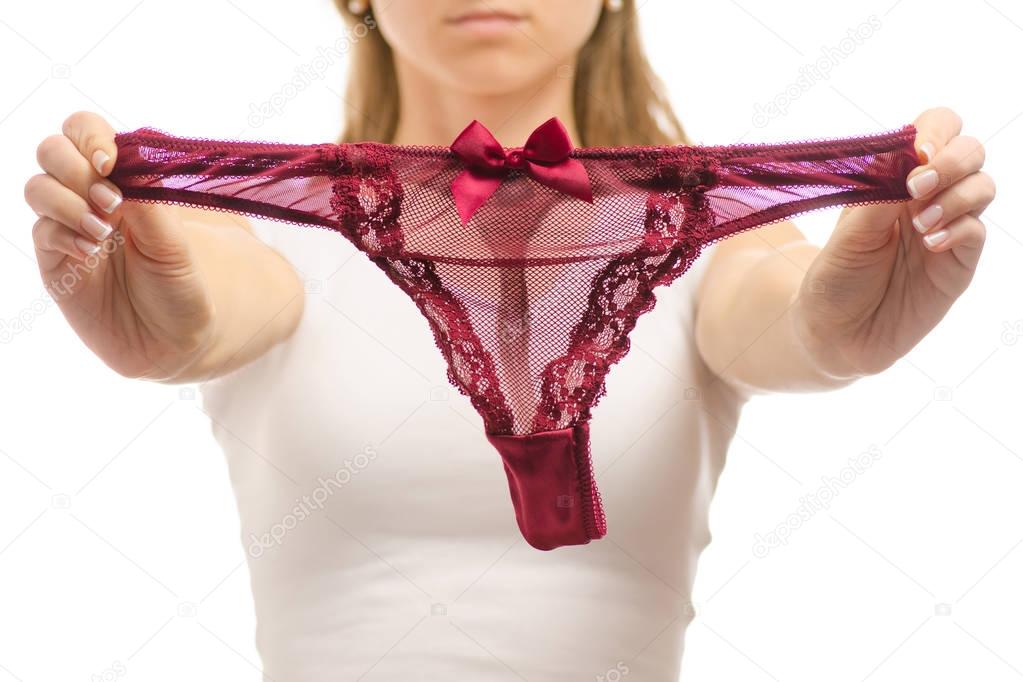 Young woman holds red thong panties