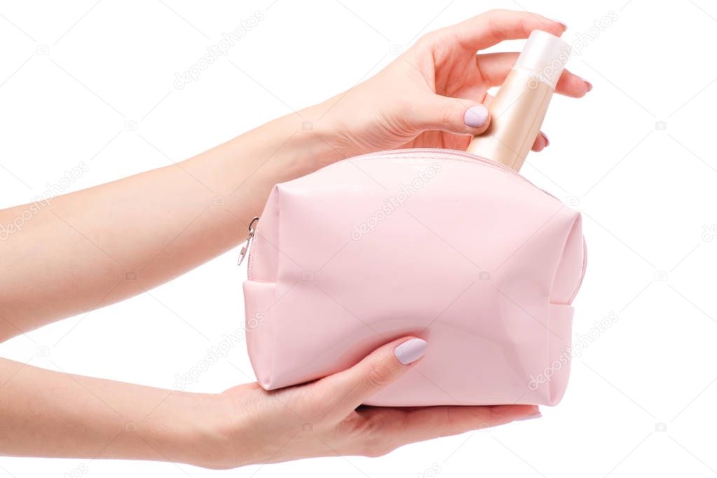 Pink open cosmetic bag in female hands with base cream beige 