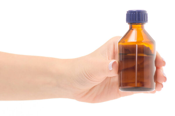 Female hand holding peroxide cotton wool in a glass jar of cotton wool