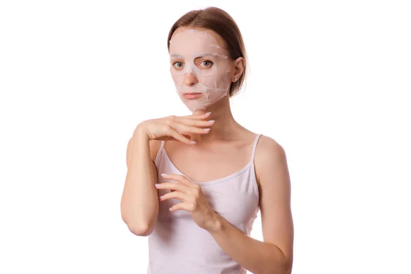 Wanita muda yang cantik masker tisu di wajahnya kecantikan kosmetik — Stok Foto