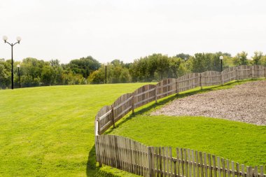 Yeşil çim ağaçlar mavi gökyüzü çit