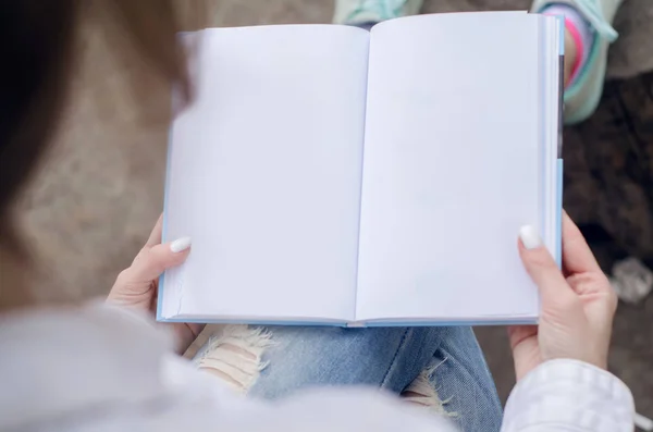 Páginas de caderno branco em branco em mãos femininas — Fotografia de Stock