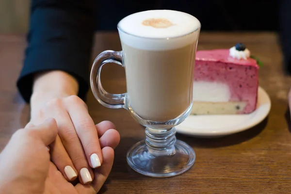 Kaffee-Latte mit Schaum und Kuchen weibliche Hand in männliche — Stockfoto