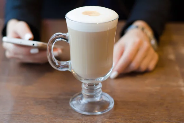 Café cappuccino teléfono móvil teléfono inteligente manos femeninas — Foto de Stock