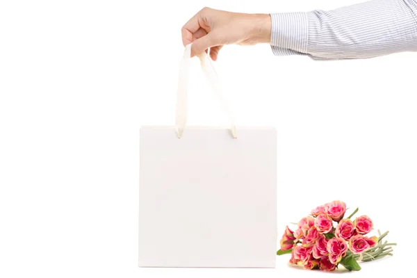 Mannen gåva händerna väska och blommor — Stockfoto