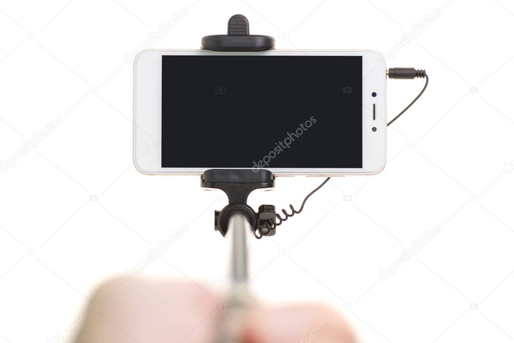 Smartphone and selfie stick in hand