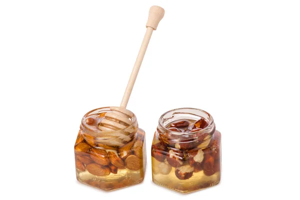 Un tarro de miel con una cuchara para nueces de miel — Foto de Stock