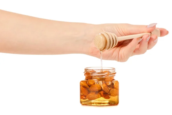 Медовая банка с ложкой для медовых орехов миндаль в руках — стоковое фото