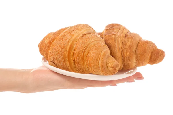 Croissanty na bílé plotně n ruka — Stock fotografie