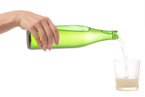 Стеклянная бутылка с содовой в руке и стекле — стоковое фото
