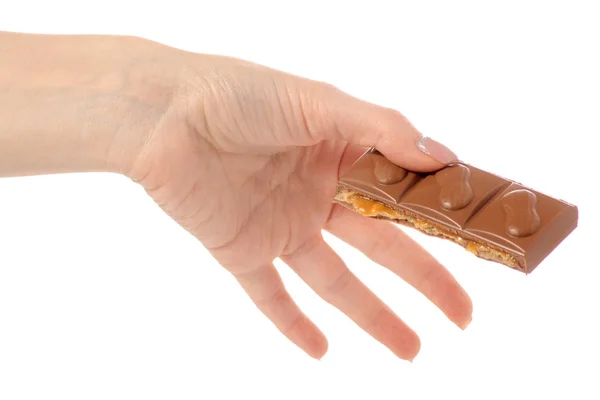 Chocolate com caramelo e nozes na mão — Fotografia de Stock