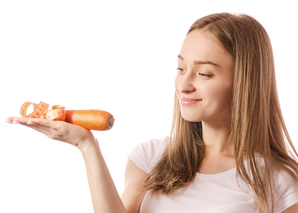 Hermosa joven sonriente sosteniendo una zanahoria y midiendo centímetro en las manos — Foto de Stock