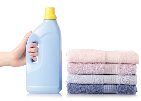 A stack of towels softener conditioner liquid laundry detergent in hand — Stock Photo, Image