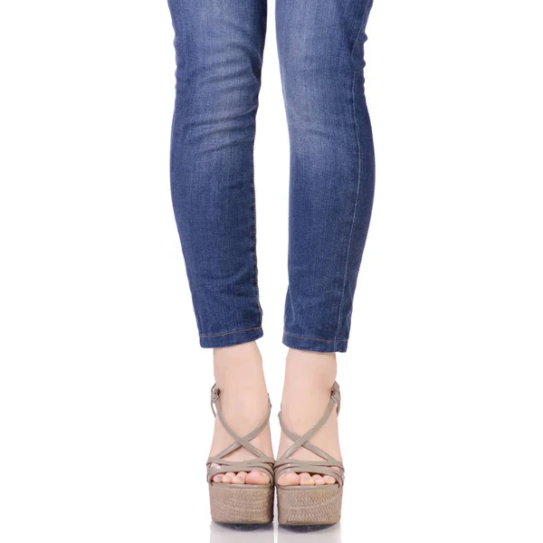 Patas femeninas en jeans y sandalias grises en cuña — Foto de Stock