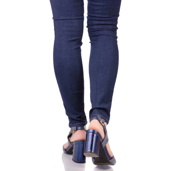 Vrouwelijke benen in jeans en blauwe sandalen schoenen — Stockfoto