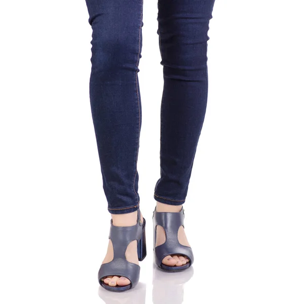 Kvinnliga ben i jeans och blå sandaler skor — Stockfoto