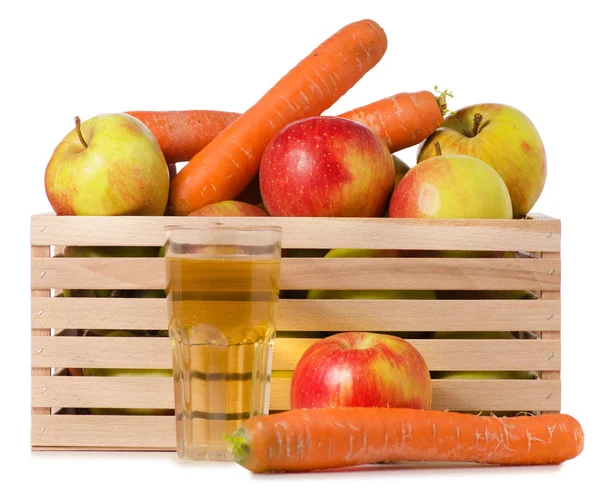 Houten kist van appels wortelen glas sap — Stockfoto
