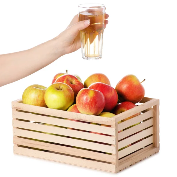 Коробка яблок стакан яблочного сока в руке — стоковое фото