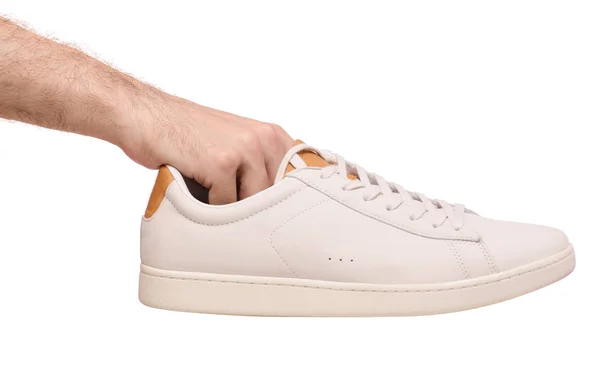 Zapatillas de deporte masculinas de cuero blanco con cordones en la mano — Foto de Stock