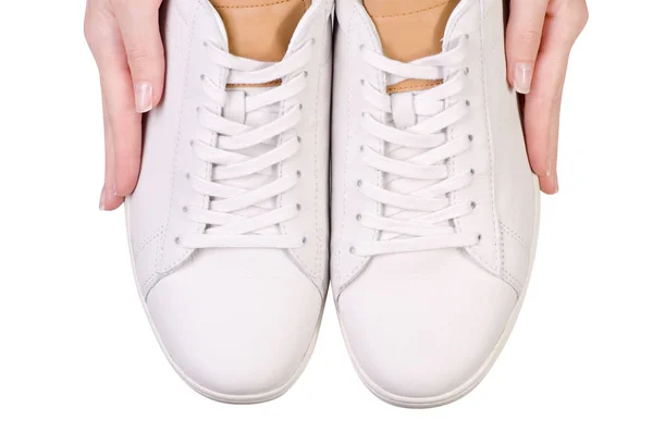 Zapatillas de deporte masculinas de cuero blanco con cordones en la mano — Foto de Stock