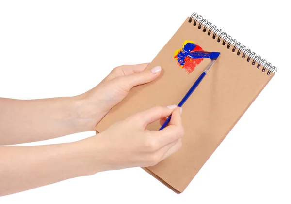 Notepad for drawing and brush with paint in hand — Stock Photo, Image