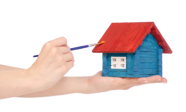Klein houten huis verf penseel in de hand Stockafbeelding