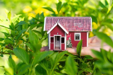 Küçük tatil evi elinde güneş yeşil bitki doğa bırakır.