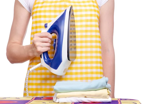 Mulher em avental com ferro tábua de engomar roupa de lavandaria — Fotografia de Stock