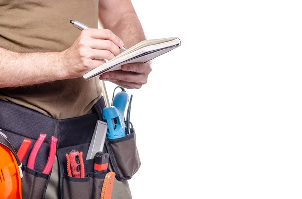 Cinto de construção em um homem com diário notebook um construtor de cinto de ferramentas caneta — Fotografia de Stock