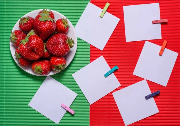 Aardbei papier voor notities op rode groene achtergrond — Stockfoto