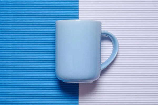 Mug biru pada latar belakang multi-warna — Stok Foto