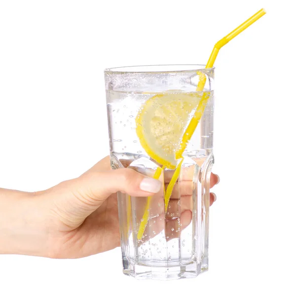 Agua carbonatada de vidrio con limón en la mano — Foto de Stock