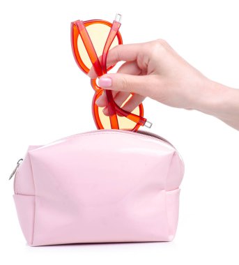 Kırmızı güneş gözlüklerini pembe makyaj çantasına koy.