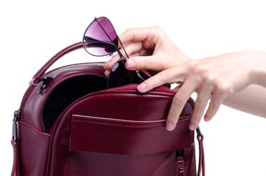 Güneş gözlüklerini kırmızı çantaya koy.