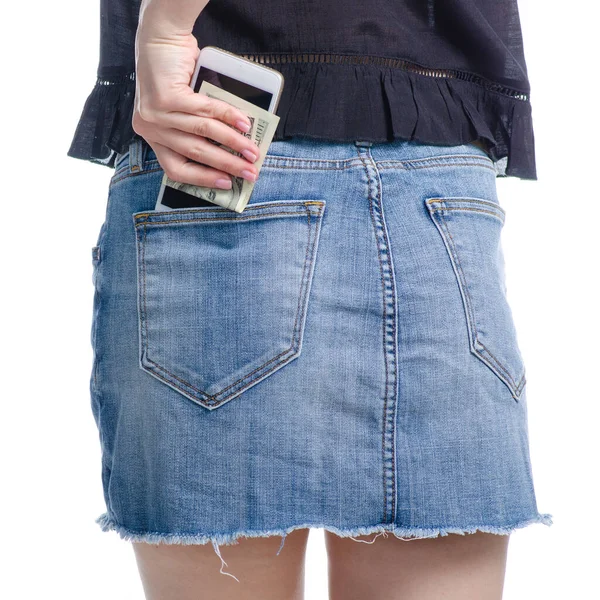 Mulher coloca telefone celular e dinheiro dólares no bolso saia jeans — Fotografia de Stock